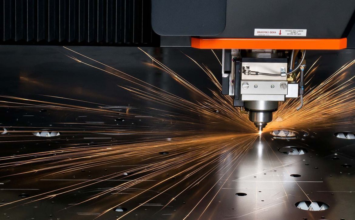 Engineer operating an industrial belt grinder, sparks flying, dark workshop, orange accents